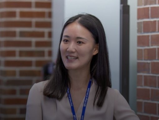 Woman in lanyard smiling.