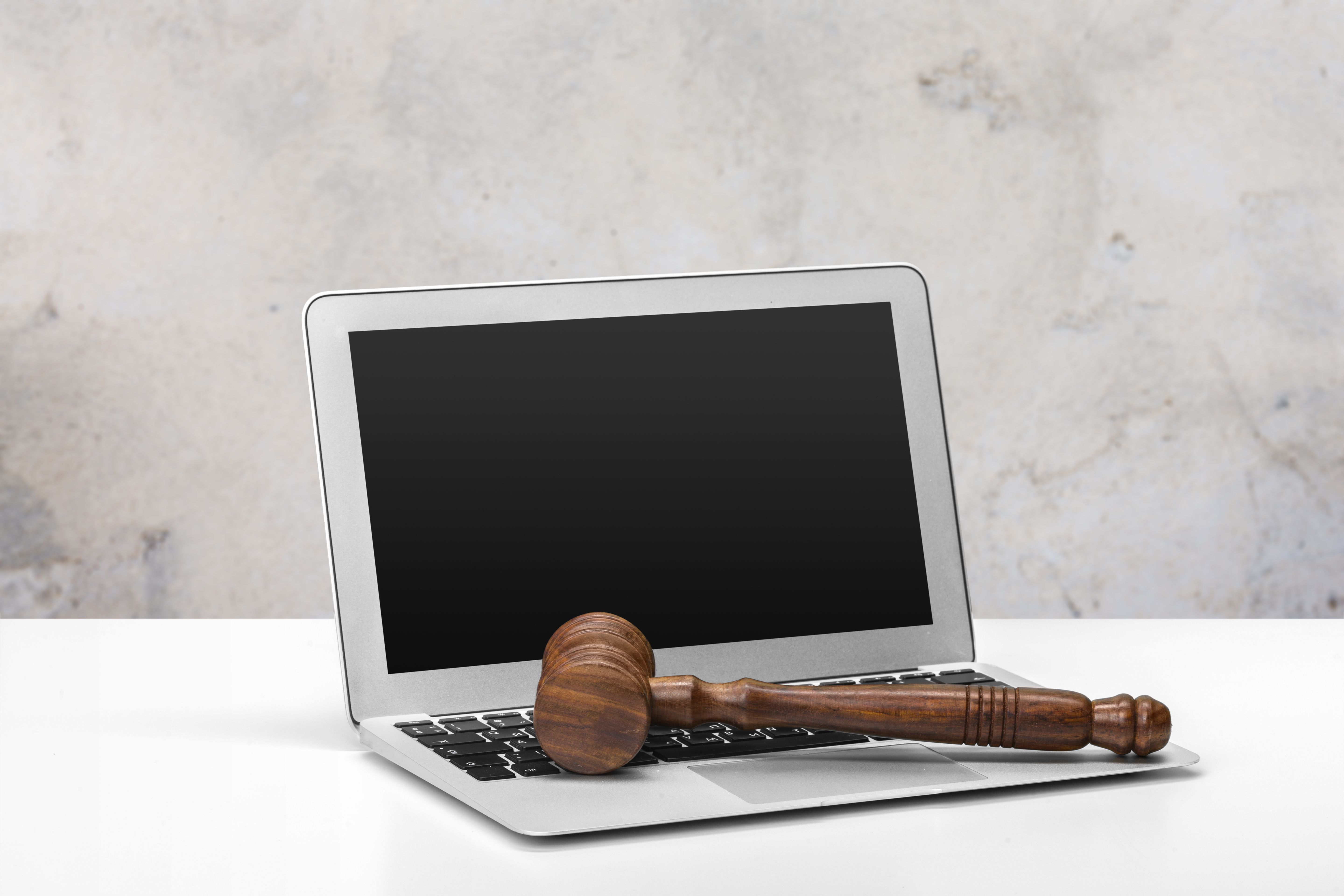 A gavel resting on a laptop
